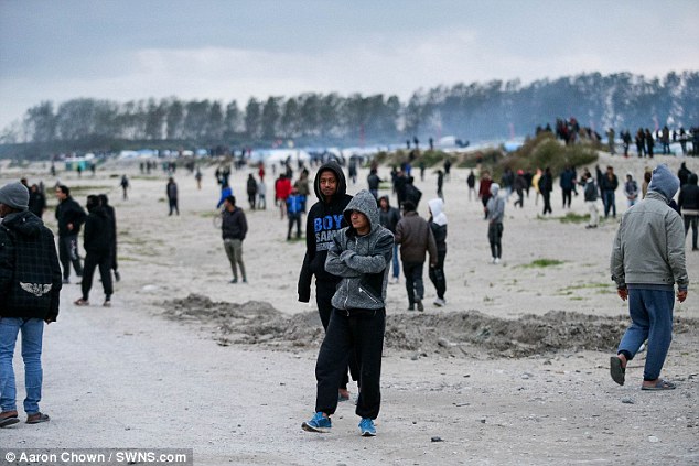Migrants from the Jungle  rush the fence surrounding the motorway leading to the ferry terminal in Calais