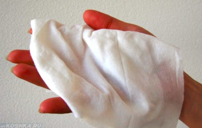 Влажная белая салфетка в руке
